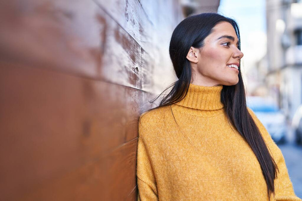 Jeune femme hispanique souriant confiant debout dans la rue - Photo, image