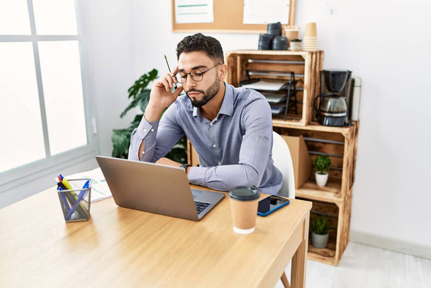 Hombre árabe joven usando portátil trabajando en la oficina - Foto, Imagen