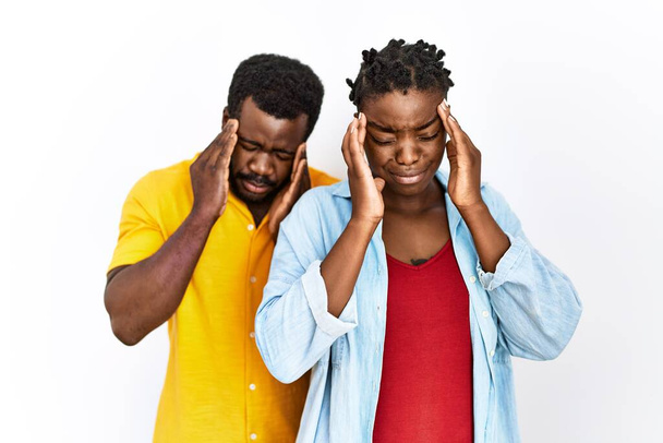 Junge afrikanisch-amerikanische Paar in lässiger Kleidung mit der Hand auf dem Kopf für Schmerzen im Kopf wegen Stress. Migräne.  - Foto, Bild