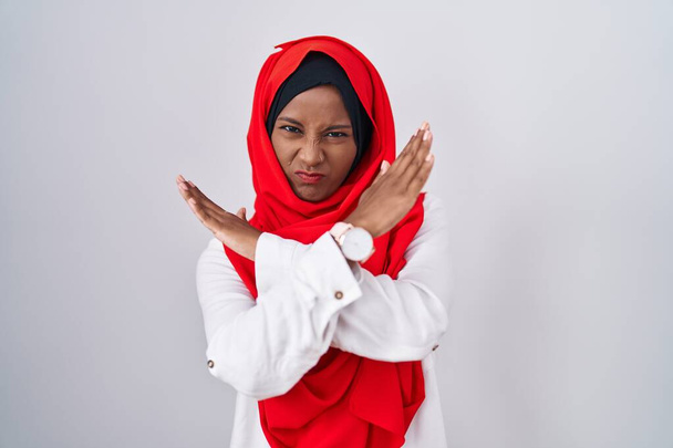 Nuori arabi nainen yllään perinteinen islamilainen hijab huivi hylkääminen ilme rajan aseita tekee negatiivinen merkki, vihainen kasvot  - Valokuva, kuva