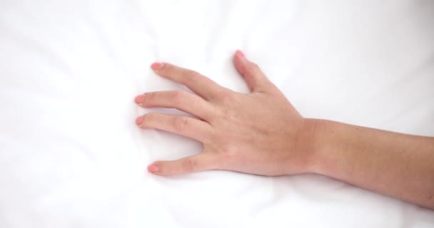 Sexy mano femenina tira y aprieta sábanas blancas en la cama. Pesadilla o dolor de sueño mejorado - Metraje, vídeo