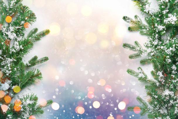 Beautiful Christmas tree branches with snow on light background with blurred lights. Mockup for design - Photo, Image