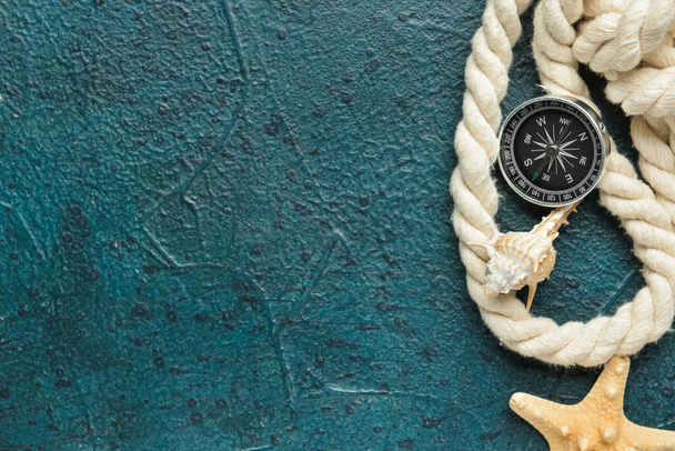 Compass, rope and seashells on color background - Foto, Imagen