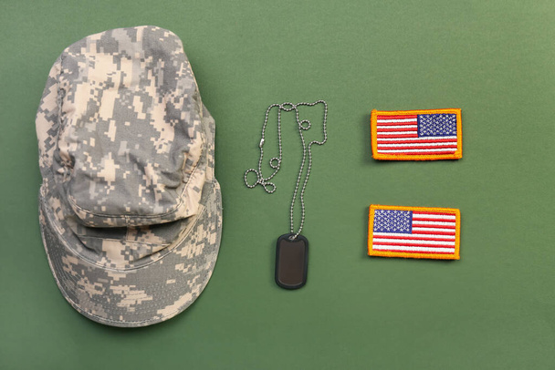 Gorra militar, etiqueta y galones del ejército de EE.UU. sobre fondo verde - Foto, imagen