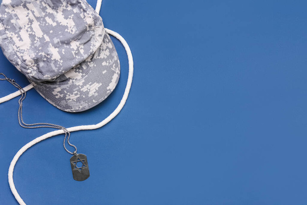 Military cap, tag and rope on blue background - Photo, Image