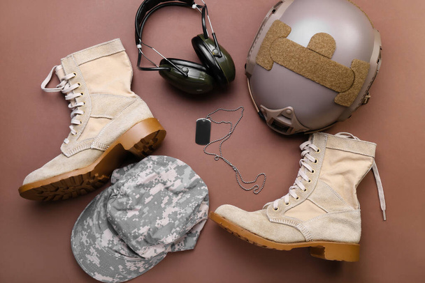 Militärschuhe, Mütze, Helm, Kopfhörer und Etikett auf farbigem Hintergrund - Foto, Bild