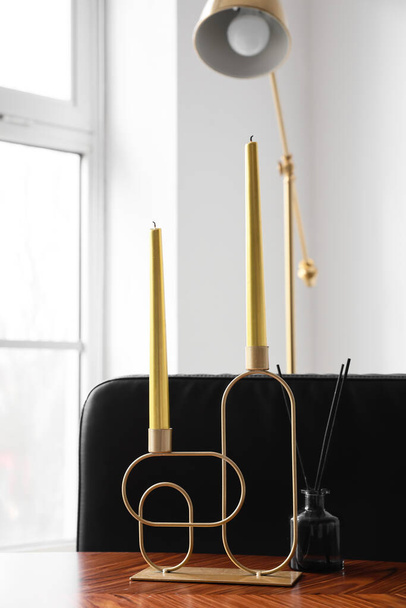 Stylish holder with candles and reed diffuser on wooden table - Foto, Bild