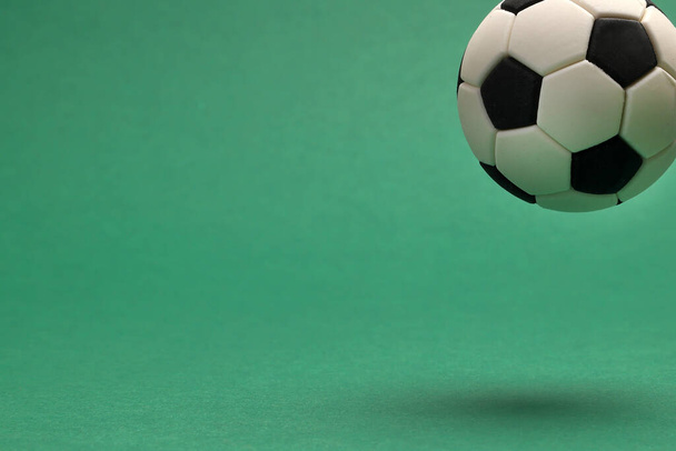 Miniatyyri lelu jalkapallo jalkapallo pallo musta ja valkoinen väri vihreä tausta kopioi teksti tilaa käsite  - Valokuva, kuva