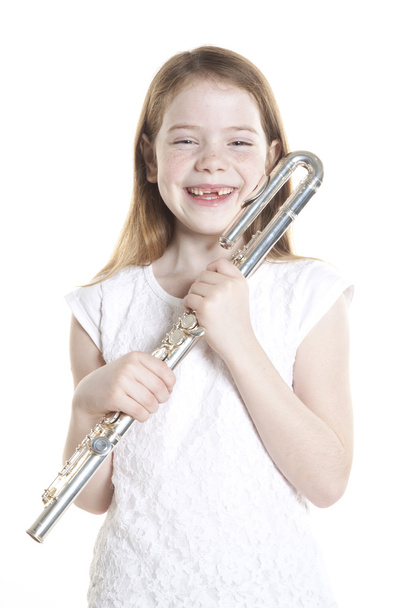 Молодая рыжая девушка держит флейту в студии
 - Фото, изображение