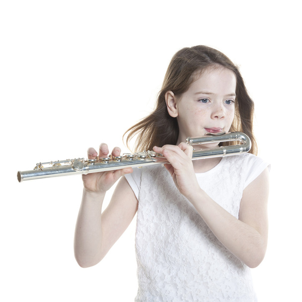 young girl with brown hair holds flute in studio - Foto, Imagen