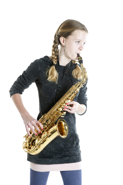 teenage girl plays saxophone in studio with white background - Fotoğraf, Görsel