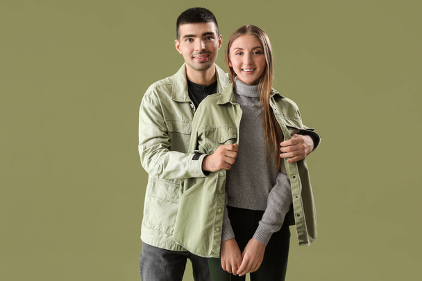 Модна молода пара в осінньому одязі на зеленому тлі
 - Фото, зображення
