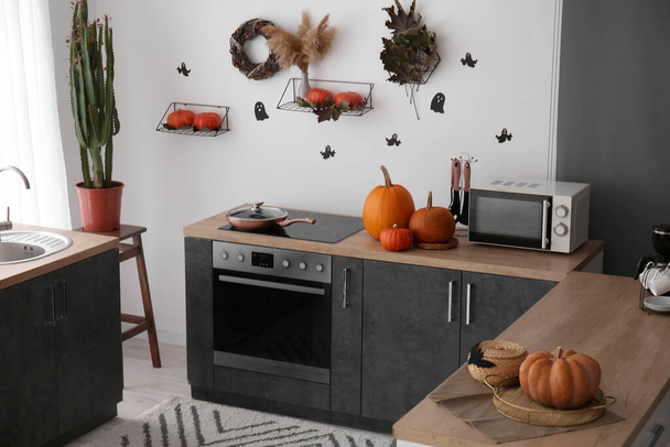 Interior de la cocina moderna decorada para Halloween con calabazas y mostradores negros - Foto, Imagen
