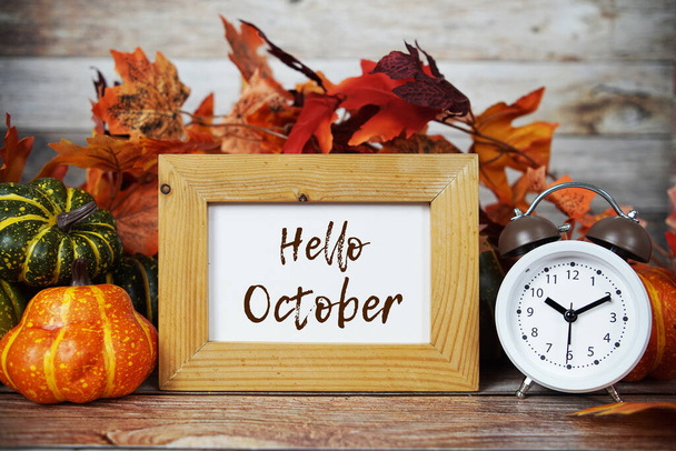 Hello October text message with alarm clock on wooden background - Фото, зображення