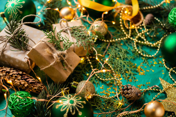 geschenkdozen op groene tafel en sparren takken. doos met lint strik aanwezig op vakantie verpakt papier. minimalistische kerstcadeaus en ballen - Foto, afbeelding