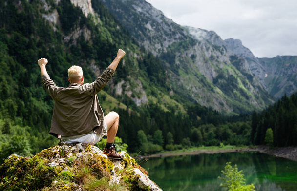 Happy hiker man winning reaching life goal, success, freedom and happiness, achievement in mountains - Fotoğraf, Görsel