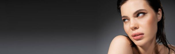 Νεαρό μοντέλο με γυμνούς ώμους που κοιτούν μακριά απομονωμένο στο γκρι, banner  - Φωτογραφία, εικόνα