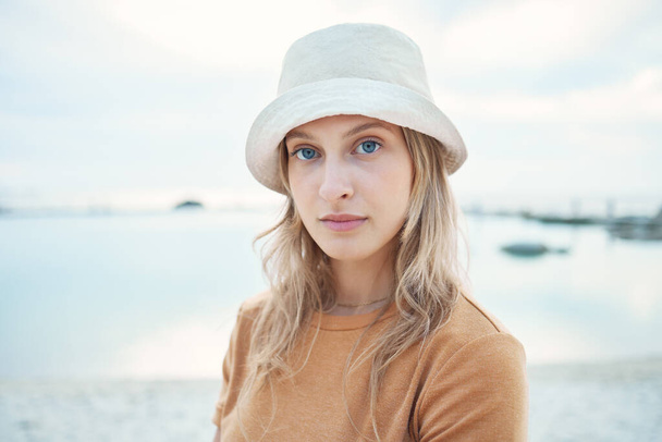 Hipster woman, holiday at the beach and portrait of calm or relaxing Norway coastal getaway trip. Peaceful summer vacation, seaside sand and young person enjoying time alone at the Oslo ocean harbor. - Foto, Imagen