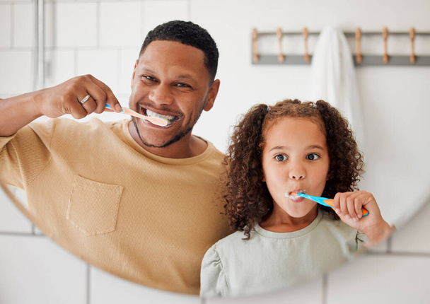 Mutlu melez baba ve kızı evdeki tuvalette dişlerini fırçalarken. Bekar bir Afrikalı Amerikalı ebeveyn kızına dişlerini korumasını öğretiyor.. - Fotoğraf, Görsel