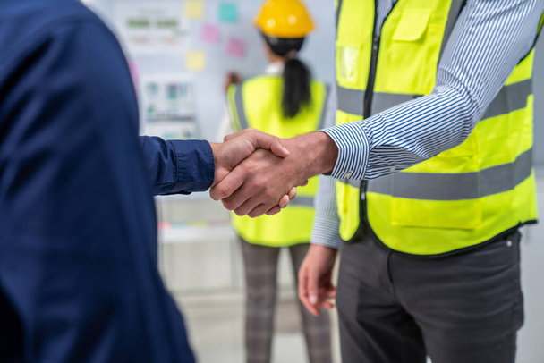 After concluding the meeting, competent investor shakes hands with engineer. Concept of the agreement between engineers and investors. - Foto, Imagem