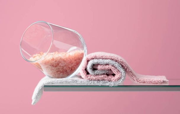 Kompozycja spa z różową solą i ręcznikami na różowym tle. Przestrzeń kopiowania. - Zdjęcie, obraz