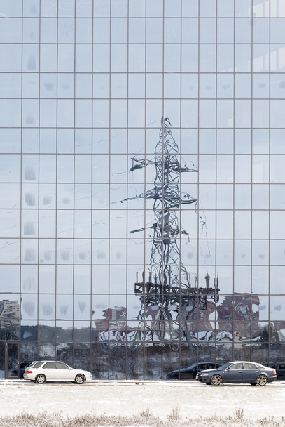 poste eléctrico reflejado en ventanas del edificio de oficinas
 - Foto, imagen