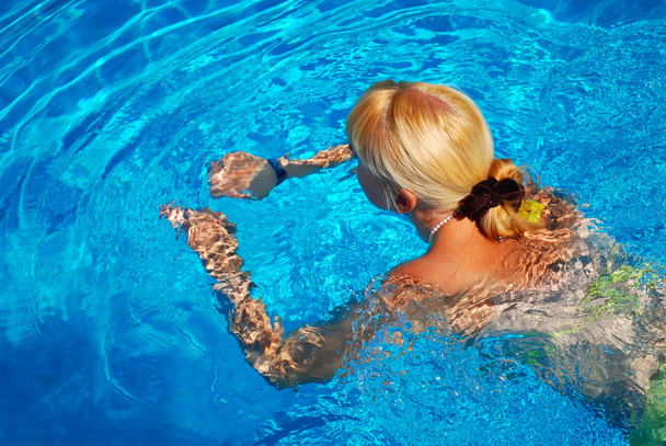 jong volwassen meisje zwemmen in het zwembad - Foto, afbeelding