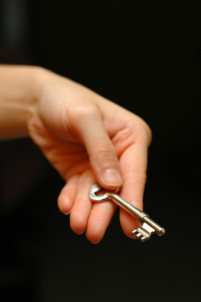 Outstretched hand holding a house key - Zdjęcie, obraz