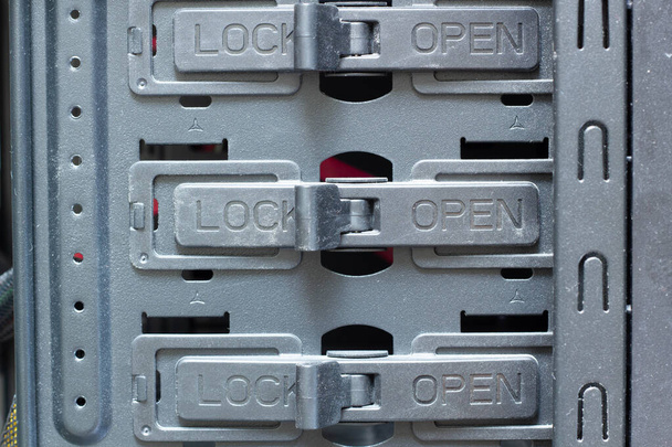Πολύ βρώμικο κλειδαριές για συσκευές Lock and Open είναι κλειστό. Διακόπτες στο διαμέρισμα για σκληρούς δίσκους, δίσκους HDD και SSD, δίσκους DVD και CD σε έναν πύργο υπολογιστή. Ηλεκτρονικός εξοπλισμός. Επισκευή ηλεκτρονικών - Φωτογραφία, εικόνα