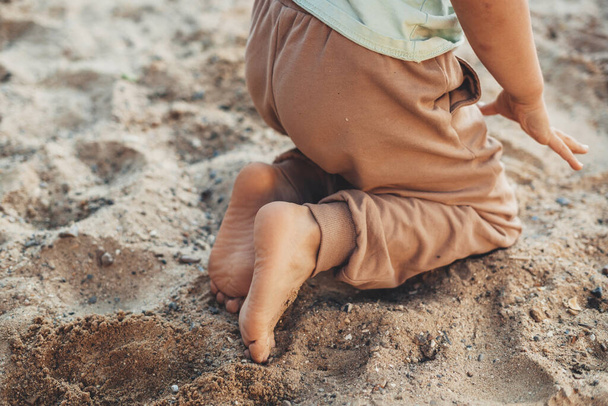 Cropped view of boys bare feet kneeling in sand while playing in garden. Happy family, childhood. Fun family. Summer outdoor fun activity. Outdoor recreation - Fotoğraf, Görsel