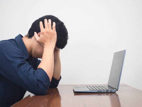 Man worker sitting working with laptop feels tried and headache - Photo, Image