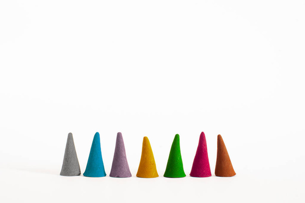 Vista frontal de cones de incenso coloridos e aromáticos com diferentes aromas de pé lado a lado e isolados em fundo branco com foco seletivo. - Foto, Imagem