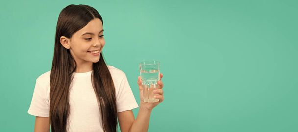 smiling girl going to drink beverage. healthy childhood lifestyle. water balance in body. Banner of child girl with glass of water, studio portrait with copy space - Photo, image
