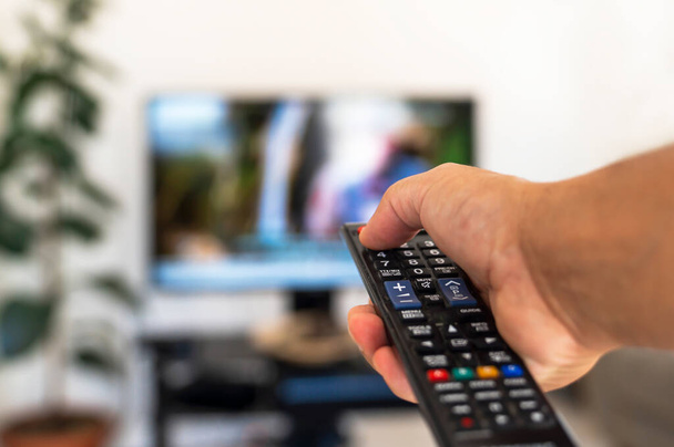 Watching tv and using remote control - Фото, зображення