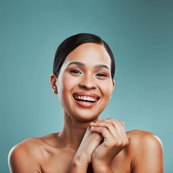 Retrato de una joven hermosa mujer de raza mixta con suave piel suave posando y sonriendo sobre un fondo verde estudio. Atractiva mujer hispana con maquillaje elegante posando en estudio. - Foto, imagen