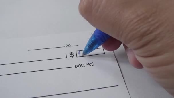αρσενικό χέρι γράφοντας αριθμούς χρημάτων κατά την επιταγή. - Πλάνα, βίντεο