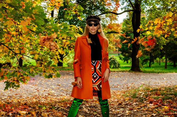 Mujer hermosa está usando ropa de otoño en el paisaje de otoño con hojas de colores. Sesión al aire libre. Moda de otoño. - Foto, Imagen
