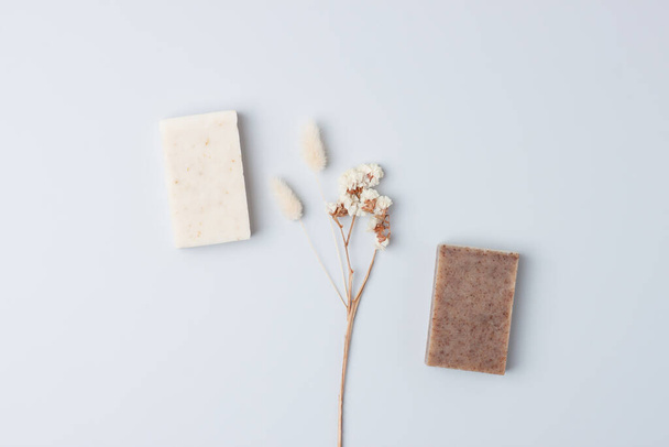 Soap with flowers on grey background. Flat lay, copy space. - Foto, Imagen