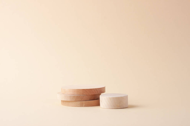 Fondo cosmetico con podio in legno su beige. Vetrina vuota per la presentazione dei prodotti cosmetici. - Foto, immagini