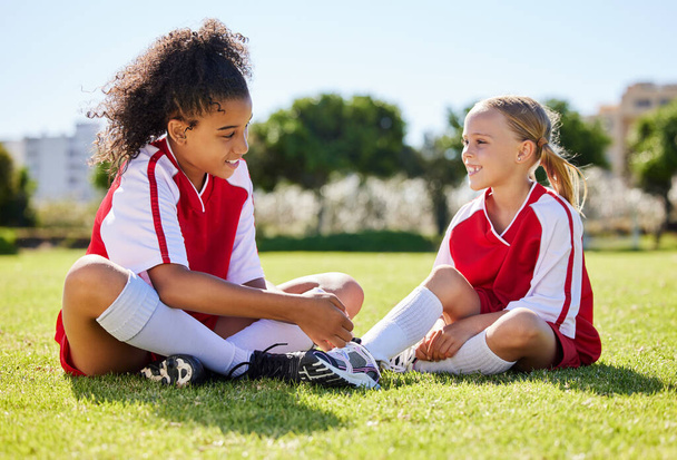 Field, friends and girl soccer children enjoy friendly conversation with smile at game break. Interracial friendship with happy kids smiling together on sports ground at football match in USA - Foto, imagen