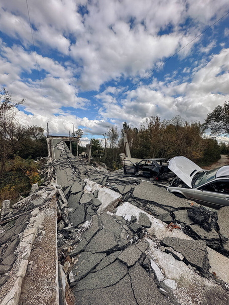 Ukrayna 'nın Kharkiv bölgesindeki Kupiansk kasabasından kurtarılan yıkılmış köprü ve yanmış arabalar. Rus bombardımanının sonucu. Savaş kavramı, Rus işgali ve askeri suçlar. - Fotoğraf, Görsel