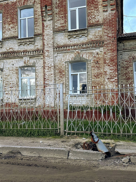 ロシアのMLRSウクライナの占領クピアンスクの町から解放された家の横にある通りのグレードの発射。ロシアの砲撃の結果。戦争、ロシアの侵略と軍事犯罪の概念. - 写真・画像