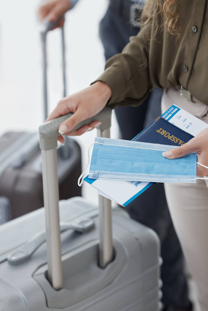 Ταξίδι, covid και συμμόρφωση closeup της γυναίκας στο αεροδρόμιο με διαβατήριο και αποσκευές, ταξιδεύουν για επαγγελματικούς λόγους κατά τη διάρκεια πανδημίας. Ασφάλεια, στέμμα και κανόνες σε αποκλεισμό από γυναίκες που ετοιμάζονται να επιβιβαστούν. - Φωτογραφία, εικόνα