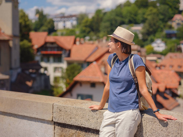 Отдыхаешь в Швейцарии, Бэрн. Леди посещает туристические объекты и достопримечательности. Женщина турист на вершине городского пейзажа вид на старый город Берн - Фото, изображение