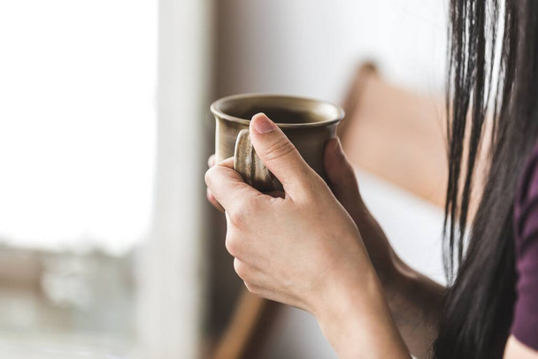 woman holding cup of coffee in hands - Foto, afbeelding