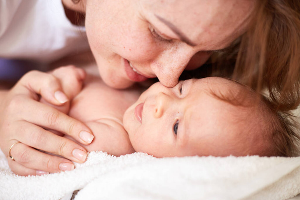 Mother Massaging Her newborn baby boy. Realistic home portrait - Valokuva, kuva