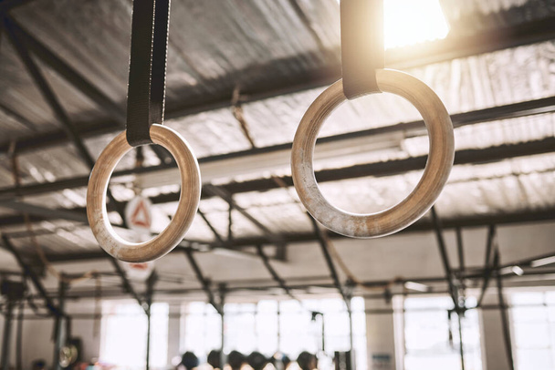 Gymnastic rings hanging in a gym. Empty gym with workout equipment. Acrobat rings hanging in a gym. Empty gym with exercise objects. Gym interior training equipment. Fitness can be flexible. - Fotoğraf, Görsel