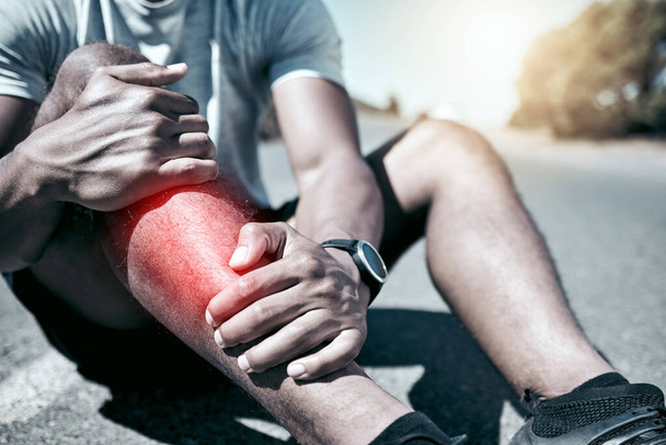 Closeup fit mixed race man holding his leg in pain while exercising outdoors. Unrecognizable male athlete suffering with shin splints highlighted by glowing cgi. You can get hurt during a workout. - Foto, afbeelding