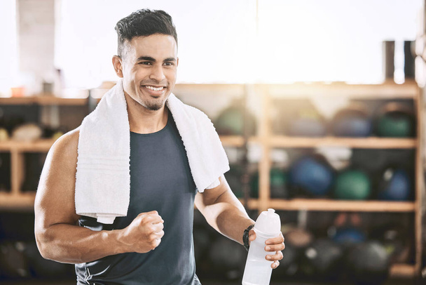 Happy trainer cheering in the gym. Fit, strong man taking a break from his workout. Bodybuilder using a towel after his exercise routine. Sporty athlete enjoying his workout routine - Foto, Imagem