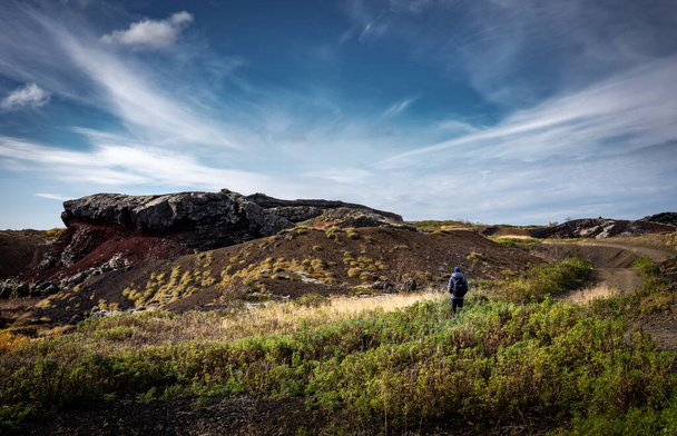 A single man hiking through volcanic landscape of Heidmork forest, Reykjavik, Iceland.  - Foto, Bild